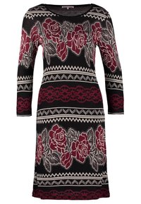 Robe à manches longues noire avec motifs de roses bordeaux, accents géométriques blancs et encolure ronde, confectionnée en tissu maille extensible.