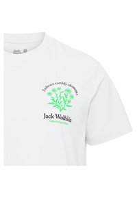 T-shirt en coton blanc avec un motif floral vert et du texte. Logo "Jack Wolfskin" en noir, en dessous : "Bien-être naturel".