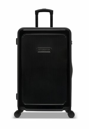 Zwarte harde koffer met verticale groeven, telescoophandgreep en vier wielen. Heeft een logo aan de voorkant en een zijhandgreep.
