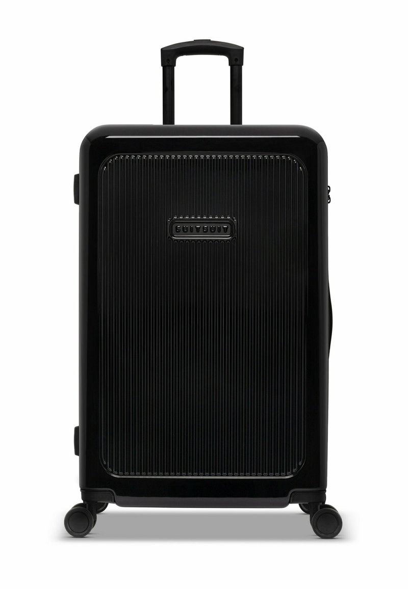 Zwarte harde koffer met verticale groeven, telescoophandgreep en vier wielen. Heeft een logo aan de voorkant en een zijhandgreep.