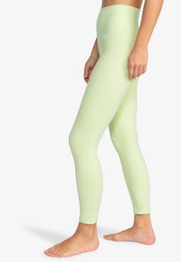 Hoog-getailleerde, felgroene leggings gemaakt van rekbaar materiaal, met een gladde textuur en een minimalistisch ontwerp zonder zichtbare logo's.