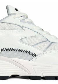 Witte sportieve schoen met een combinatie van leer en mesh materialen, grijze accenten en zwarte stiksels, een gevoerde tong en een gestructureerde zool.