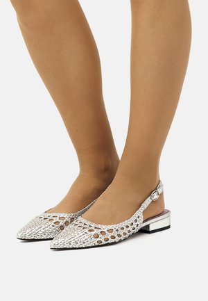 Des chaussures à talons ouverts en argent tressées, avec des bouts pointus, dotées d'un petit bloc de talon et d'un accent en bouton sur la sangle.