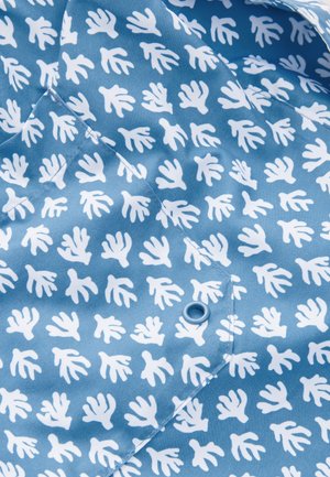 Blauer Stoff mit einem wiederholten Muster aus weißen Handabdrücken. Glatte Textur mit einem Knopfdetail in passendem Blau.