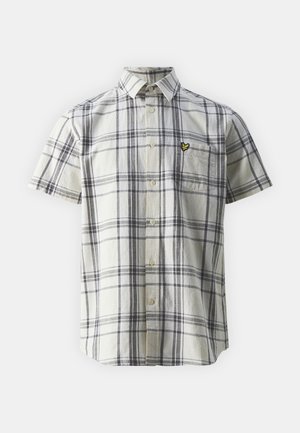 Chemise à manches courtes à carreaux crème et marine, avec fermeture à boutons et poche poitrine gauche ; présente un petit détail de logo jaune.