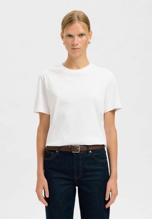 Witte katoenen T-shirt met korte mouwen, ronde halslijn, gecombineerd met donkerblauwe spijkerbroek en een bruine riem. Eenvoudig ontwerp, zonder patronen.