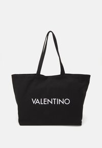 Svart tygkasse med två hållbara handtag och vit text "VALENTINO" tryckt tydligt på framsidan.