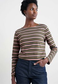 Tricou cu mâneci lungi în dungi, în culori verzi, roz și maro; are un decolteu tip bărci și o croială confortabilă. Asortat cu pantaloni din denim închis.