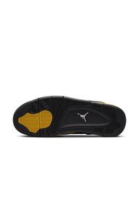 Suola di una sneaker nera e gialla con un design testurizzato, materiale in gomma e un prominente logo Jumpman bianco.