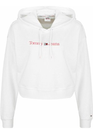 Sudadera recortada blanca hecha de tela suave, con un logo rojo de "Tommy Jeans" y un pequeño acento de bandera negra y roja en la manga.