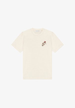 T-shirt color crema a maniche corte con collo tondo e piccolo disegno stampato di una chiave e una targhetta da motel sul petto a sinistra.