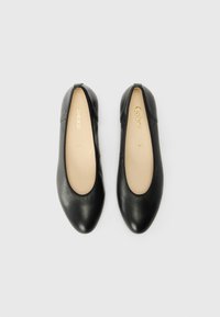 Sorte lær ballet flade-sko med rund tå, glat overflade og beige såler. Har minimal syning og et elegant design.