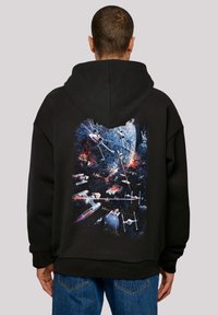 Felpa nera con cappuccio che presenta una grafica vivace sulla schiena con immagini a tema spaziale, tra cui navi stellari ed esplosioni in vari colori.
