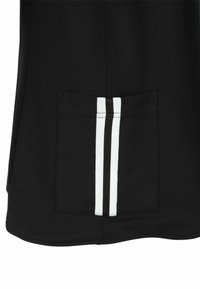 Schwarzes Oberteil mit einer Fronttasche, die weiße und schwarze vertikale Streifen aufweist. Der Stoff wirkt glatt mit einer festen Textur und einem abgerundeten Saum.
