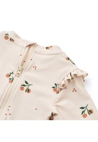 Traje de baño en rosa pálido con pequeño estampado de hojas naranjas y verdes, con cierre de cremallera y bordes de las mangas con volantes para un mayor detalle.