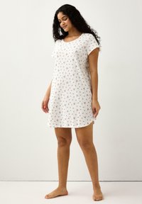 Bílá noční košile s krátkými rukávy s květinovým vzorem, žebrovanou texturou, kulatým výstřihem a délkou ke kolenům. Měkká látka, pohodlný design.