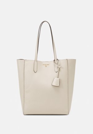 Crèmekleurige leren totebag met twee lange hengsels en een kleine hangende pouch, met subtiele gouden merkletters aan de voorkant.