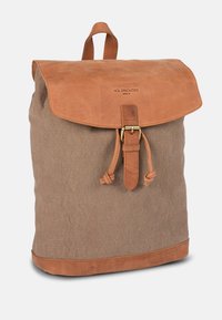 Brown canvas backpack with a tan leather flap, adjustable leather strap closure, and a top handle for carrying convenience.