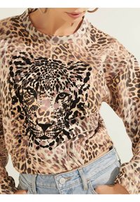Sudadera de estampado de leopardo con mangas largas, con un diseño de cara de leopardo negra y con lentejuelas en el centro; tejido suave y texturizado, y corte relajado.