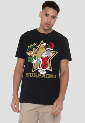 Black cotton t-shirt featuring a graphic of cartoon characters celebrating with gifts, a gold star background, and the word "SURPRISE!" in bold, glittery letters.