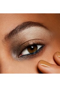 Nærbillede af et øje med neutral øjenskygge, forbedret med mørk eyeliner. Huden har en glat tekstur og varme undertoner.