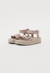 Lys beige plattform sandaler med justerbare stropper, teksturert fotseng og gummisåle. Inkluderer forsterket tå og anklestøtte.