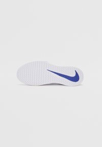 Nike apavu zole baltā gumijā, ar teksturētu virsmu un zilu swoosh akcentu. Noapaļota purngala un plakana forma noslēdz dizainu.