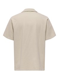 Chemise beige à manches courtes en tissu texturé avec un col large vue de dos.