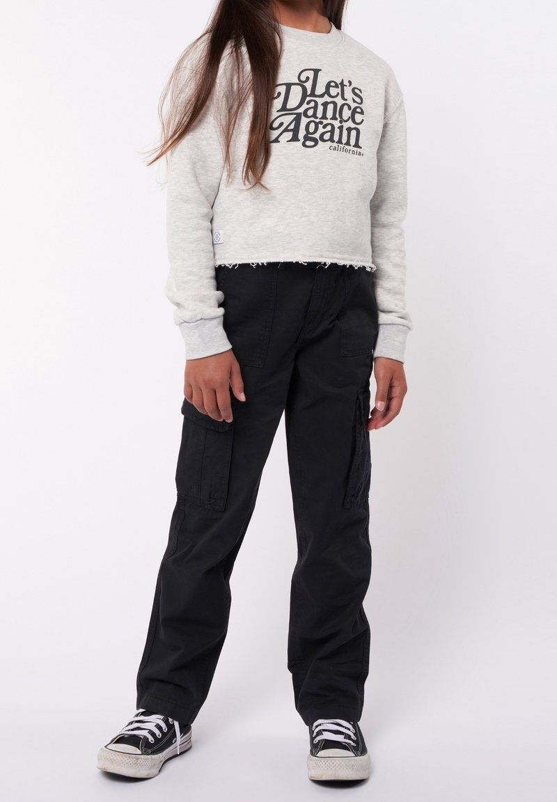 Sweat-shirt gris court avec l'inscription "Let's Dance Again", associé à un pantalon cargo noir avec poches latérales et des baskets noires à semelles blanches.