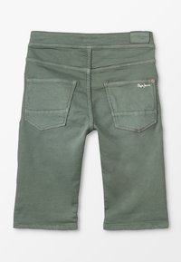 Zielone bawełniane szorty o gładkiej fakturze. Posiadają pięć kieszeni i przeszycia dekoracyjne. Logo marki znajduje się na tylnej kieszeni.