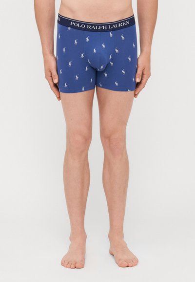 Tengerészkék boxer alsónadrág puha anyagból, ismétlődő fehér polo logós mintával és fekete derékpánttal, amelyen "POLO RALPH LAUREN" szöveg olvasható.
