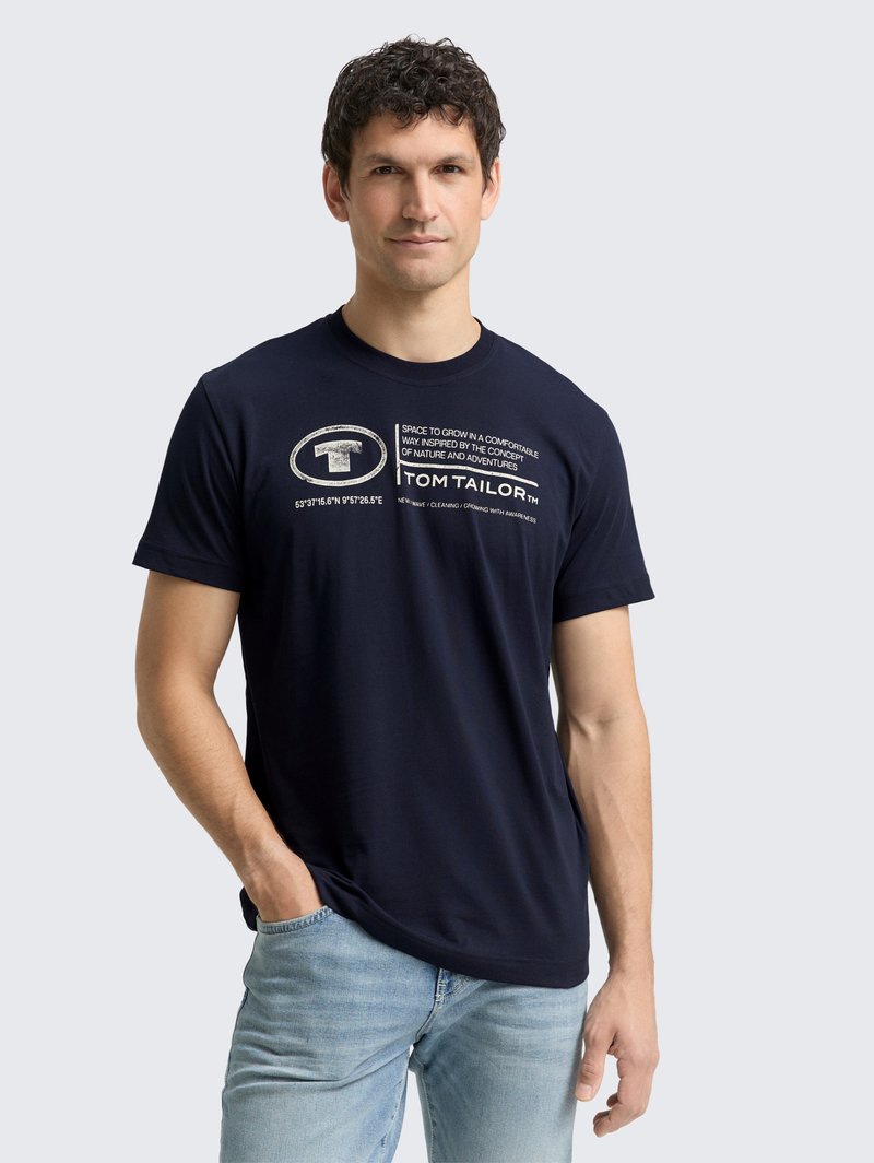 Camiseta de algodón azul marino con cuello redondo, mangas cortas y estampado gráfico texturizado. Presenta un corte relajado y un dobladillo ligeramente curvado.