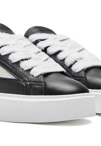 Black leather sneakers with plush white laces, featuring a textured finish and a thick white platform sole. Contrasting accents along the sides.
