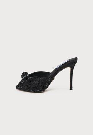 Mule negro de tacón alto con punta abierta, adornado con cuentas brillantes y una pequeña hebilla decorativa en la tira frontal.