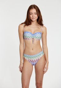 Bikiny set s farebným zigzagovým vzorom. Vrchná časť má zhrnuté stredné zloženie, nastaviteľné ramienka a kosticu. Nohavičky sú so zvýšeným pásom.