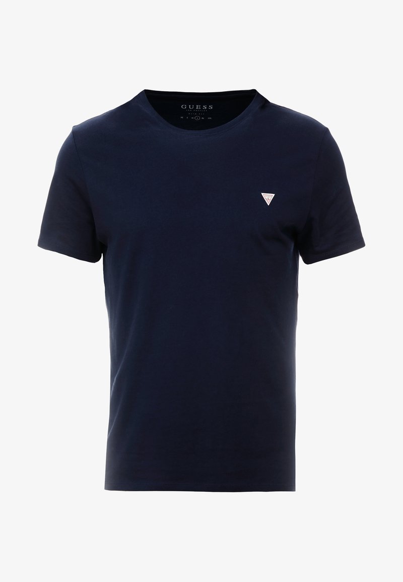T-shirt en coton bleu marine avec un col rond, des manches courtes et un petit logo triangulaire blanc sur le côté gauche de la poitrine. Texture lisse.