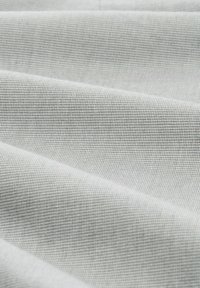 Tela gris claro con un tejido fino y texturizado. La superficie muestra patrones sutiles con una textura suave y lisa y pliegues que caen.