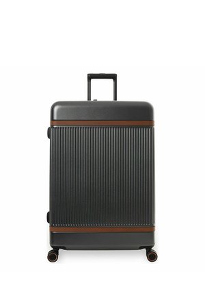 Musta kovaulkoainen matkalaukku pystysuuntaisilla uurteilla, ruskeat vaakasuorat korostukset, vedettävä kahva ulostettu ja neljä pyörivää pyörää valkoisella taustalla.