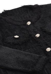 Cardigan nero fluffy con un tessuto testurizzato e fili d'oro, adornato con bottoni simili a perle in impostazioni floreali.