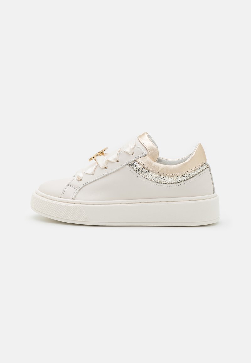 Sneaker à plateforme blanche avec lacets en ruban satin, languette de talon dorée et détail pailleté argenté le long de la partie arrière.