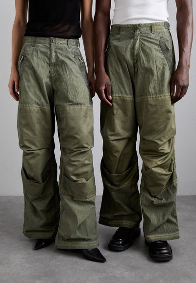 Olivgrüne Cargo-Hose mit lockerer Passform, ausgestattet mit mehreren Taschen und Reißverschlüssen, aus einem strukturierten Stoff mit matter Oberfläche.