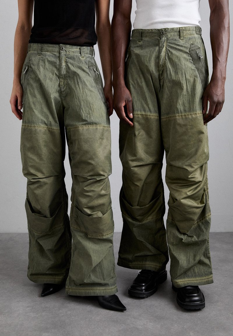 Olivgrüne Cargo-Hose mit lockerer Passform, ausgestattet mit mehreren Taschen und Reißverschlüssen, aus einem strukturierten Stoff mit matter Oberfläche.
