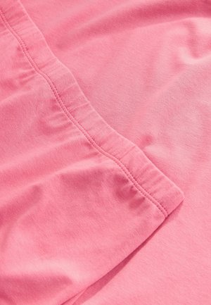Artimas rožinės medžiagos vaizdas, aiškiai matoma elastinga juosmens juosta ir siuvimo detalės.