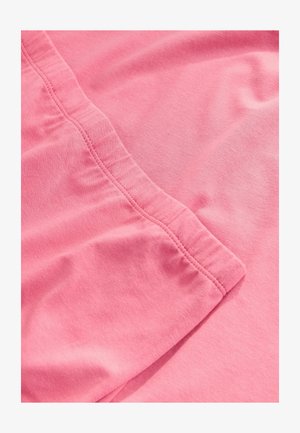 Närbild av rosa tyg med synligt resårband och söm detaljer.