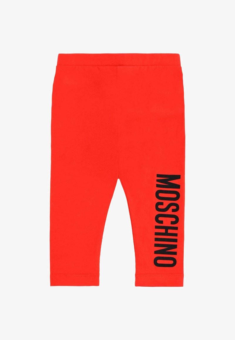 Leggings en coton rouge avec une coupe ajustée. Texte "MOSCHINO" noir imprimé verticalement sur le côté gauche. Texture lisse avec une taille élastique.