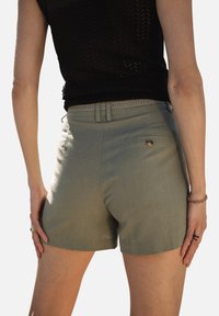 Shorts en kaki en tissu texturé, dotés d'une taille ajustée avec passants de ceinture et d'une poche arrière avec un détail de bouton.