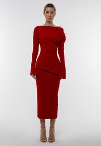 Červené rebrované šaty s off-shoulder výstrihom, priliehavým korzetom a rozšírenými rukávmi. Sukňa strednej dĺžky má diagonálny lem a hladkú textúru.