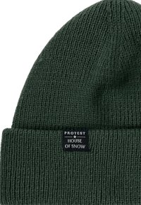 Groene gebreide muts met een geribde textuur en omgeslagen rand. Voorzien van een zwart label met de tekst "PROTEST HOUSE OF SNOW."