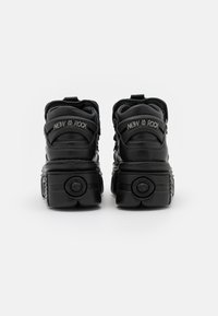 Black platform sneakers with a textured, glossy finish. Features padded collars, chunky soles, and "NEW ROCK" branding on the back.