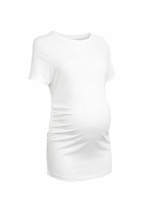 T-shirt de maternité blanc, à manches courtes, avec des détails froncés sur les côtés, en coton doux, col rond, silhouette ajustée pour s'adapter au ventre qui s'arrondit.